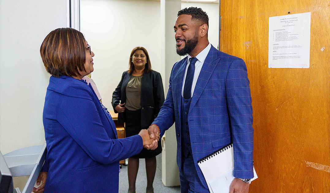Minister of MPAAI shaking hands with Public Officers